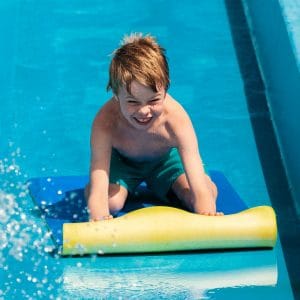 A little boy plunges down a water slide